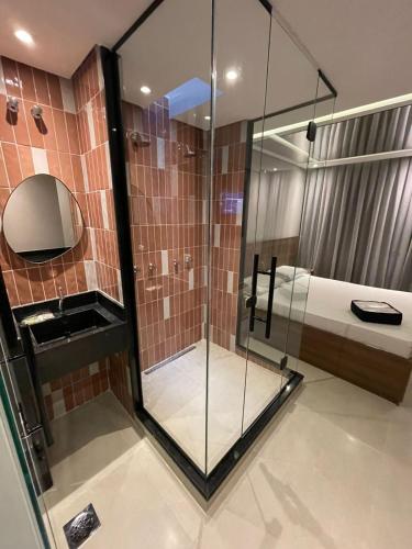 een glazen douche in een badkamer met een bed bij Hotel Cantareira (Adults Only) in Sao Paulo