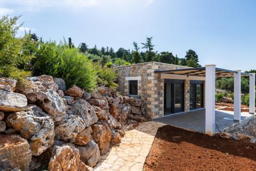 a stone house with a rock wall at BlueSkyline Owner's Listing, By Hellocrete in Chania Town