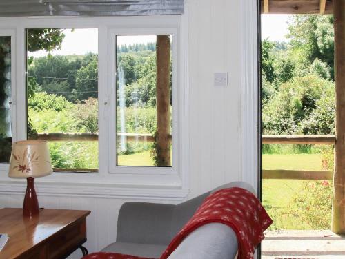 a room with windows and a couch and a table at The Garden House - Uk10987 in Llandogo