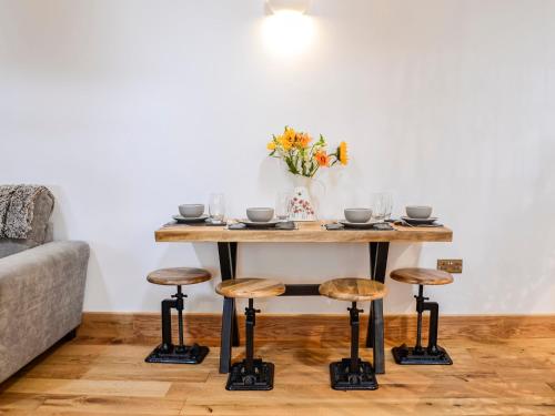 a table with stools in a living room at Cullew Bothy in Pearsie