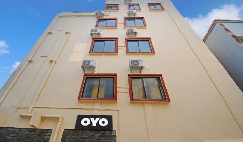 a building with red windows and an ovy sign on it at Super Hotel O Shri Ashirbad Palace in Urāli
