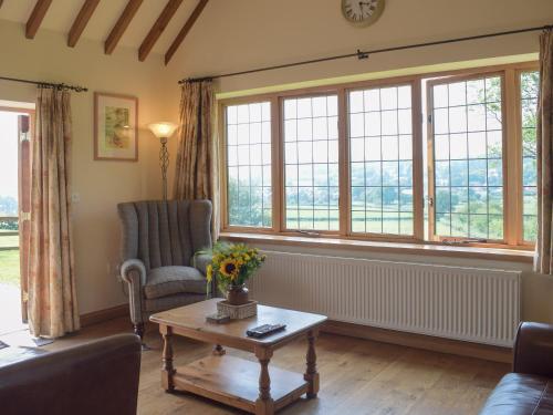 a living room with a couch and a table and windows at Talog Barn-Uk31366 in Tregynon