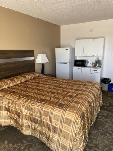 a hotel room with a bed and a kitchen at Hilltop Motor Inn in Elk Point
