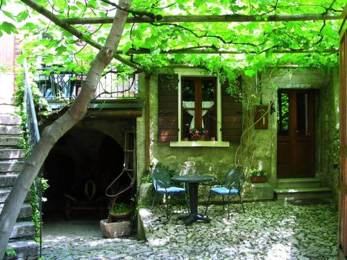 eine Terrasse mit 2 Stühlen, einem Tisch und einem Fenster in der Unterkunft Apartment Attico in Tignale