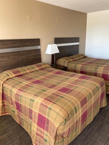 a hotel room with two beds and a lamp at Hilltop Motor Inn in Elk Point