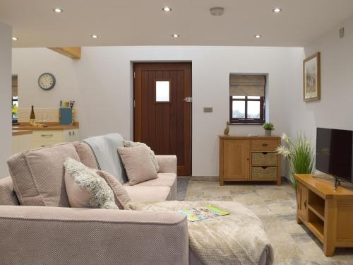 ein Wohnzimmer mit Sofa und Fernseher in der Unterkunft Bluebell Cottage - Uk12988 in Monington