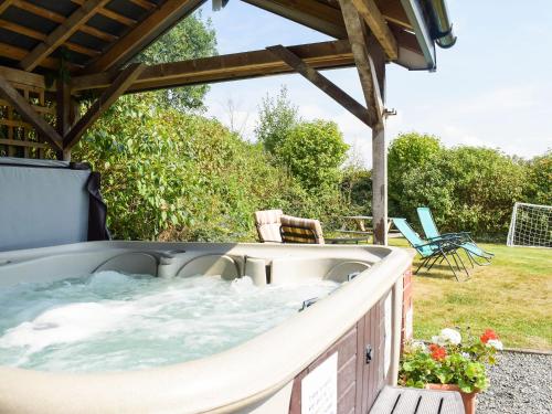 eine Whirlpool-Badewanne auf der Terrasse eines Hauses in der Unterkunft Heyope Cottage in Llangunllo