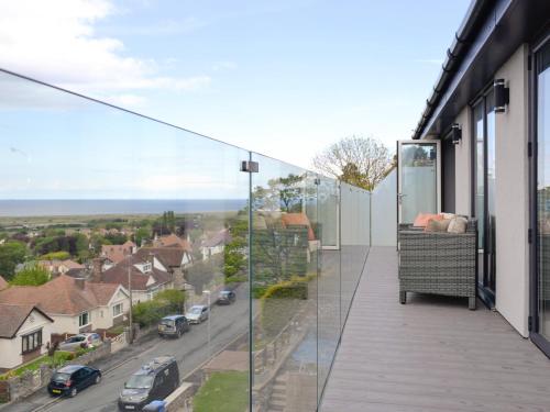 a balcony with glass walls and a view of a street at Hillside Retreat in Prestatyn