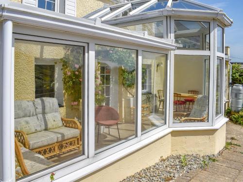 un giardino d'inverno con tavolo e sedia di Sanctuary Cottage ad Aberdaron