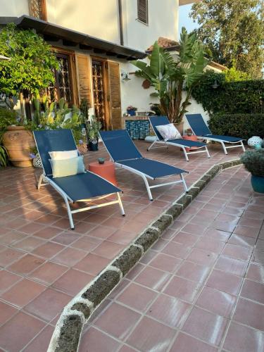 three blue lounge chairs sitting on a patio at La Casa di SASI in Sabaudia