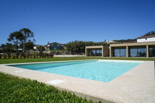a swimming pool in front of a house at Quintinha Pilares da Terra in Marinhas