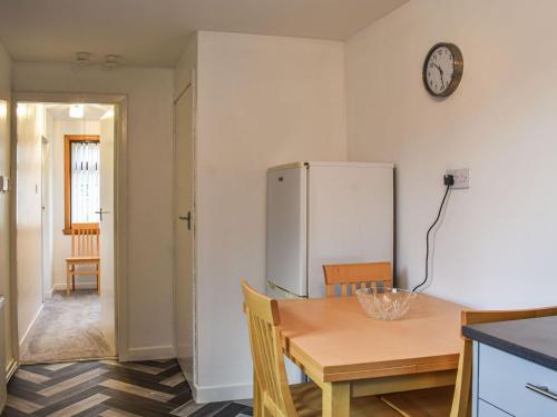una cocina con una mesa y un refrigerador en Belger Cottage, en Inverallochy