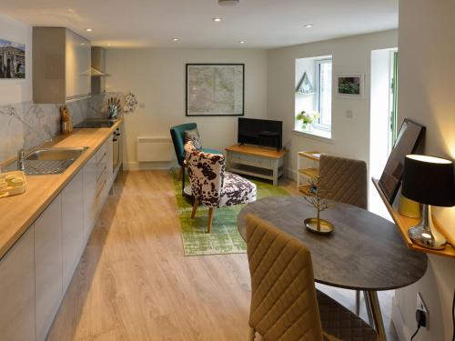 een keuken en woonkamer met een tafel en stoelen bij Hope Cottage - Uk40055 in Aberfeldy
