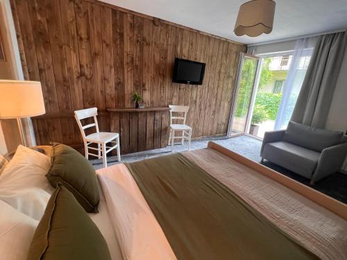 a bedroom with a bed and a couch and a television at Spokój na Pienińskiej in Krościenko