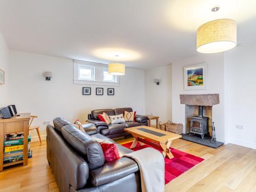 een woonkamer met een bank en een open haard bij Rose Cottage - Uk39245 in Inverness