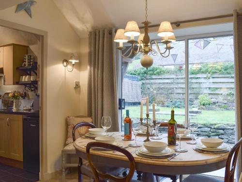 a dining room with a table and a window at Smiddy Cottage in Aberfeldy