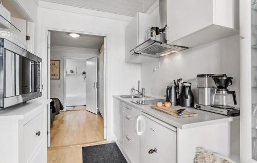 a kitchen with white cabinets and a counter top at Cozy Apartment In Aakirkeby With Wifi in Åkirkeby