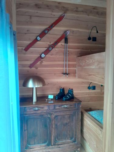 a room with a wooden wall with a lamp and skis at Villa Hortensia in Bagnères-de-Bigorre