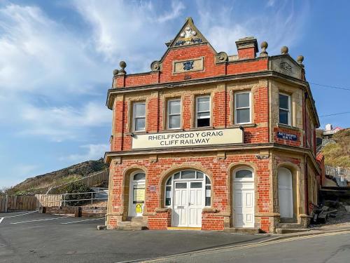 an old brick building with a sign on it at Cliff Railway Apartment in Aberystwyth