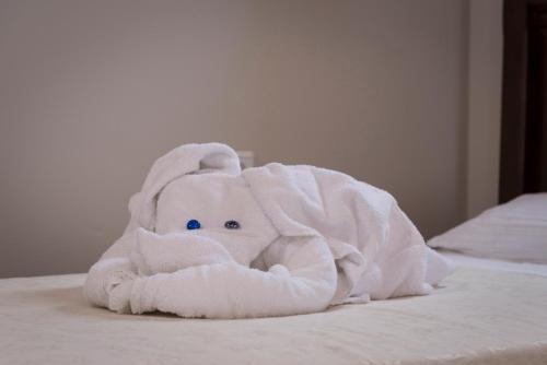 a white towel elephant sitting on a bed at Athina Luxury Villas in Xamoudhokhórion