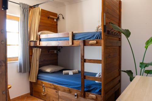a bunk bed with a blue bed in a room at Aldeia Caiçara Surf House in Sagres