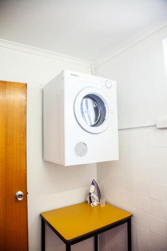 a washer and dryer above a table in a bathroom at Tudor Inn Newcastle in Newcastle