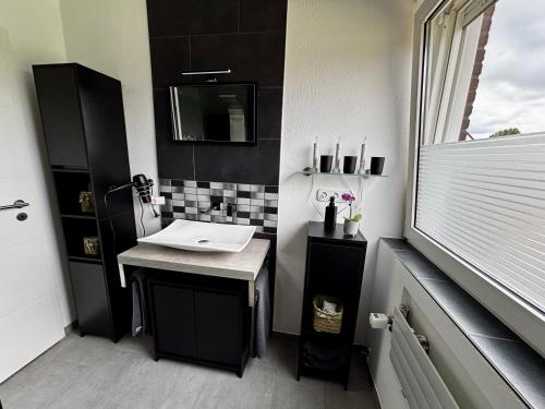 a small bathroom with a sink and a mirror at Ferienwohnung Micaela in Haselünne