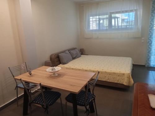 a small room with a bed and a table and chairs at Villa Afrodite in Néa Péramos