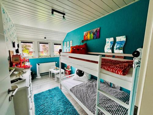 a bedroom with two bunk beds and a blue wall at Ferienwohnung Micaela in Haselünne