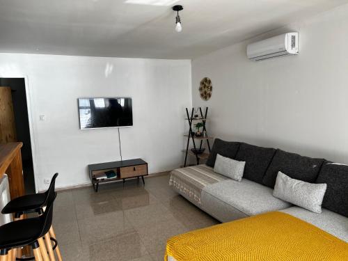 a living room with a couch and a tv at Coin paisible du nord in Acoua
