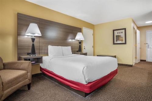 a hotel room with a large bed and a chair at Best Western Plus Bessemer in Bessemer