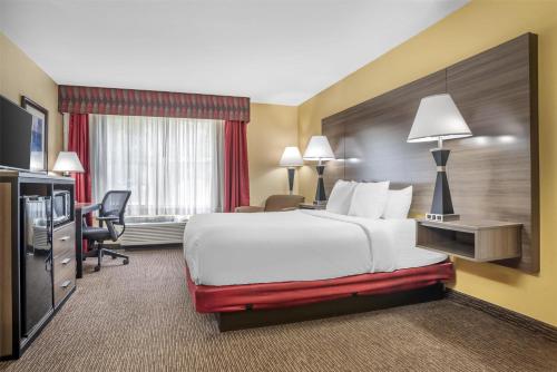 a hotel room with a large bed and a desk at Best Western Plus Bessemer in Bessemer