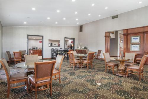 a dining room with tables and chairs and a kitchen at Best Western Plus Bessemer in Bessemer