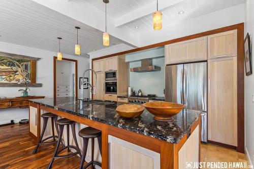 a kitchen with a counter with two wooden bowls on it at Maui Hideaway by the Beach in Paia