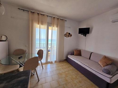 a living room with a couch and a glass table at Corfu Glyfada Menigos Resort 25 in Glyfada