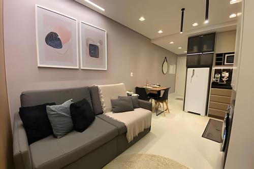 a living room with a couch and a table at Studio Premium em Torres - 450mts da Praia da Cal - Ar condicionado - Tv Smart - Wifi - Garagem - Aceita Pet in Torres