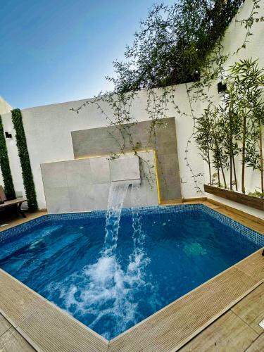 a swimming pool with a water fountain at DARZAYNAH in Monastir