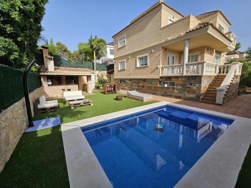 una casa con piscina delante de una casa en Amazing Villa with swimming pool, en Torrent