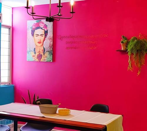 a dining room with a pink wall at Departamento climatizado in Monterrey