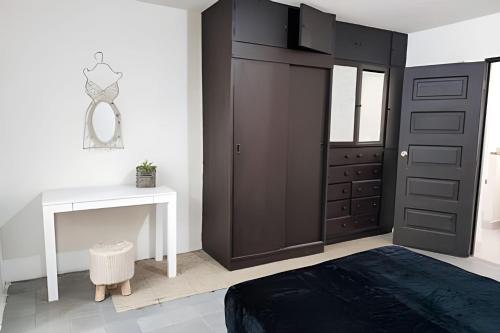 a bedroom with a black cabinet and a white desk at Casa Fundidora in Monterrey
