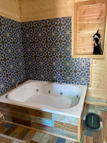 a bath tub in a bathroom with a wall at Latibule Adahan Guest House in Ayvalık