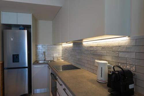 a kitchen with a white refrigerator and a sink at Avali Deluxe Apartments in Lygia