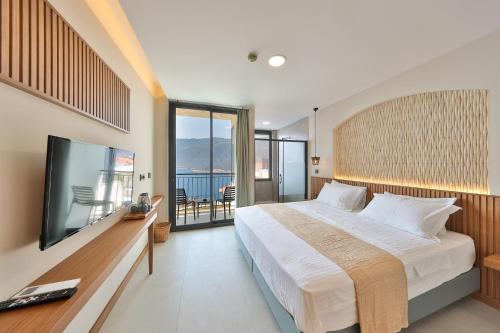 a bedroom with a large bed and a flat screen tv at Lyxos Hotel in Kas
