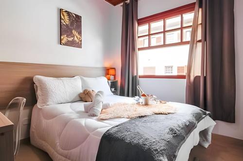 Un dormitorio con una cama con un osito de peluche encima. en Apê Inteiro| 2Qts| Estacionamento| Wi-Fi 350| Pet Friendly| Ao Lado do Parque das CEREJEIRAS, en Campos do Jordão