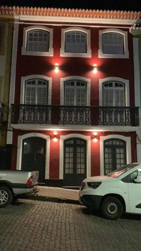 a white car parked in front of a red and white building at Cristal apartamentos 1ºdireito Praça Velha in Angra do Heroísmo