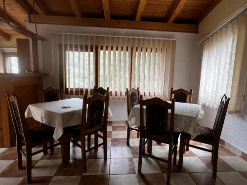 a dining room with a table and chairs and windows at Resort Komovi in Kravlja