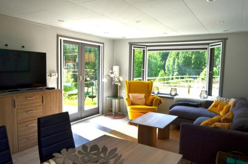 a living room with a couch and a tv at Nature cottage on wooded valley in Lii