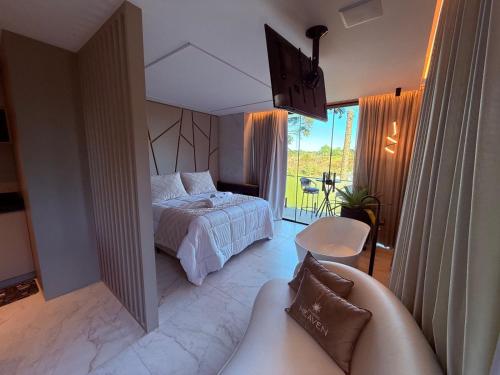a bedroom with a bed and a couch in it at Studios Heaven in Gramado