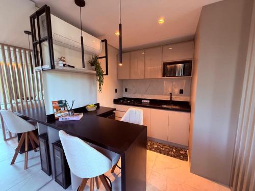 a kitchen with a black counter and white cabinets at Studios Heaven in Gramado