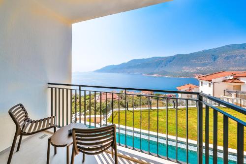 a balcony with two chairs and a view of the ocean at Lyxos Hotel in Kas
